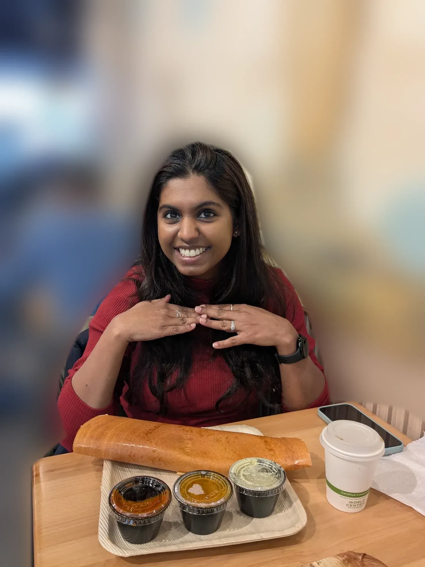 Portrait of Tinu Thomas, smiling at a restaurant table.